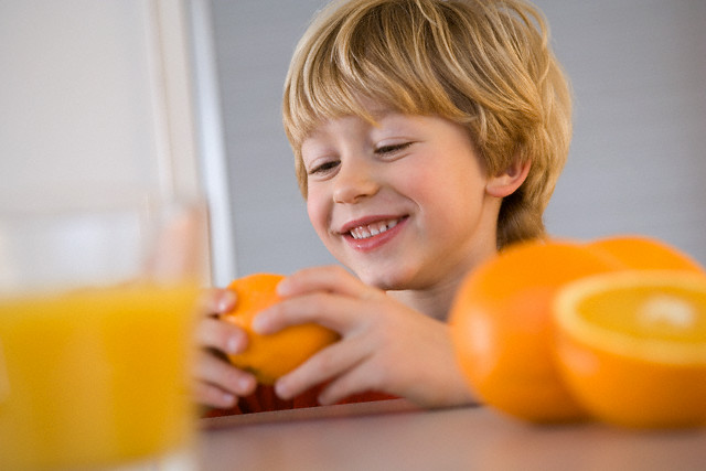 Young Boy Eating Oranges